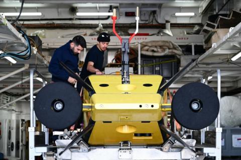 Des techniciens préparent le robot sous-marin Ulyx à bord du navire scientifique L'Atalante, amarré au port de Brest, le 15 juin 2025