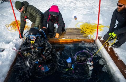 Un plongeur est extrait des eaux glacées lors d'un stage scientifique de plongée polaire, le 14 mars 2026 dans le lac de Kilpisjärvi, à l'extrême nord-ouest de la Finlande
